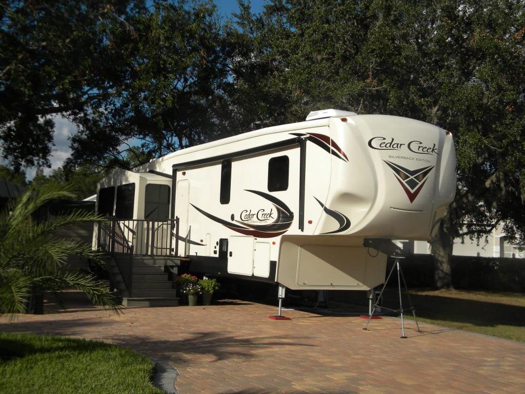 A white rv parked in the middle of a driveway.