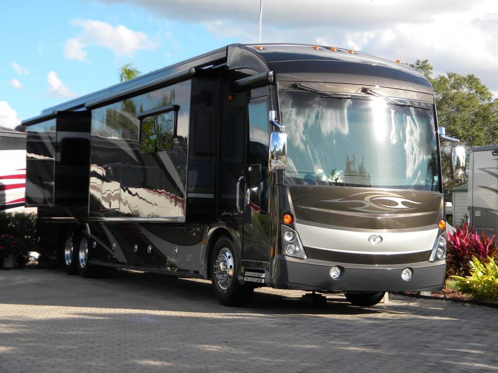 A large brown and black bus is parked on the street.